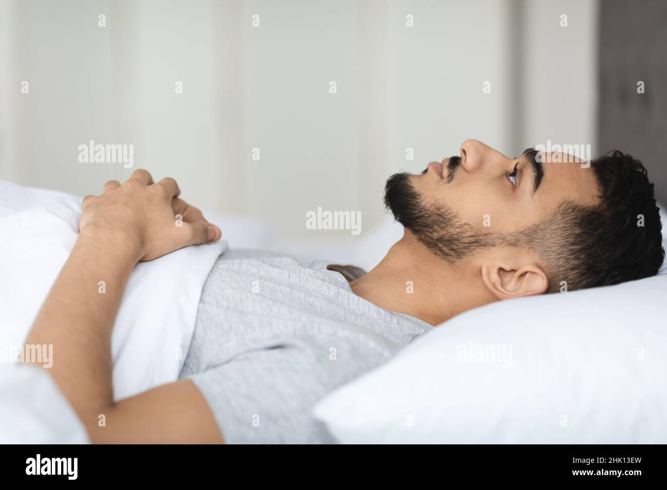 Konzept Der Schlaflosigkeit. Junger Mann Aus Dem Nahen Osten Liegt Im Bett Mit Offenen Augen Stockfoto