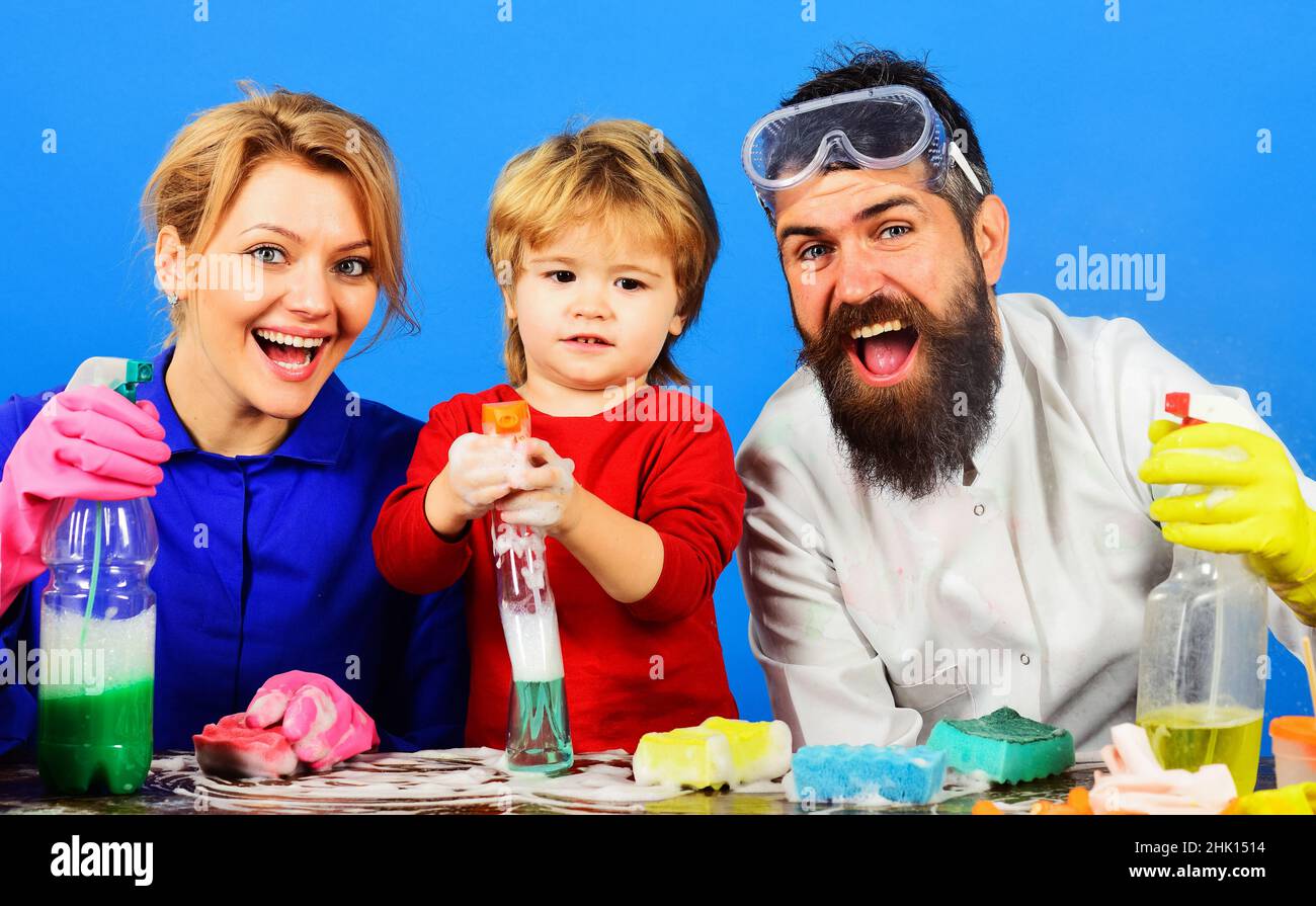 Reinigungstag. Happy Family putzt gemeinsam im Haus. Nettes Kind spielt mit Clearing Spray. Stockfoto