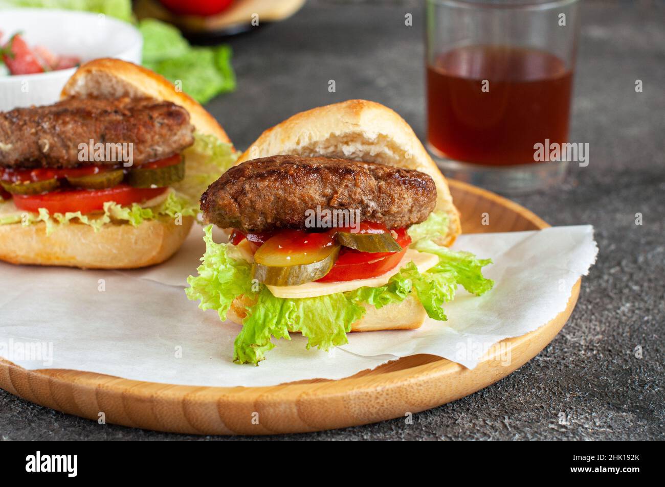 Hausgemachte Burger auf einem Holzteller. Nahaufnahme. Stockfoto