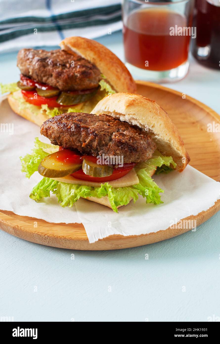 Hausgemachte Burger auf einem Holzteller. Nahaufnahme. Stockfoto