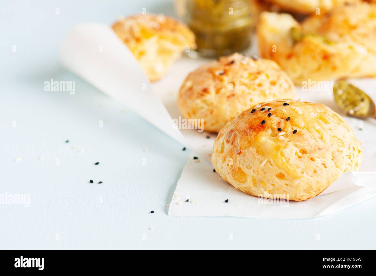 Hausgemachte kleine Käse-Abendbrötchen mit Sesam auf einem Backpapier. Stockfoto