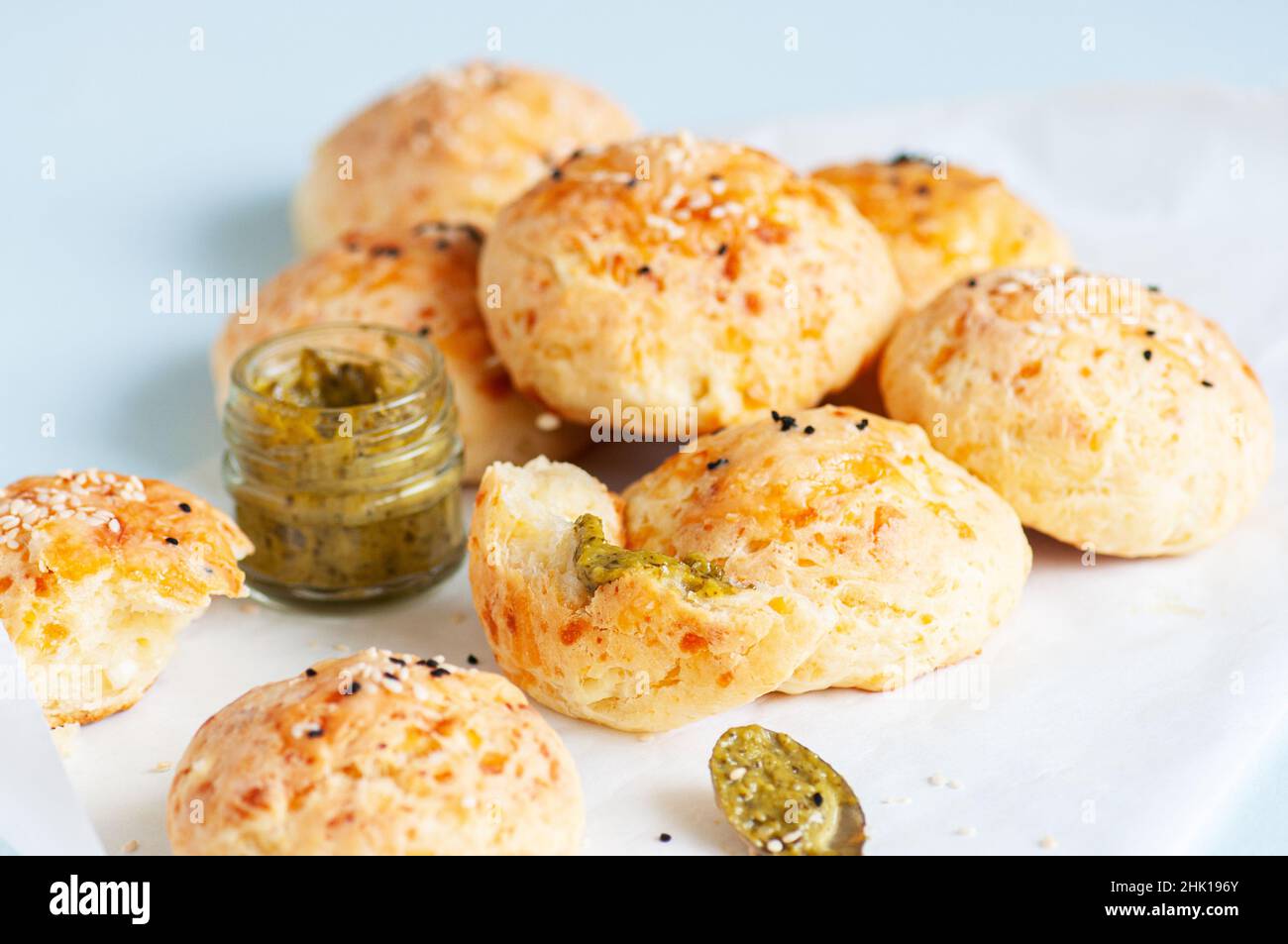 Hausgemachte kleine Käse-Abendbrötchen mit Sesam auf einem Backpapier. Stockfoto