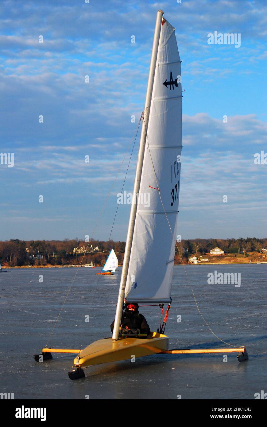 Ein Fahrer auf einer Eisyacht zieht in den gefrorenen Hafen Stockfoto
