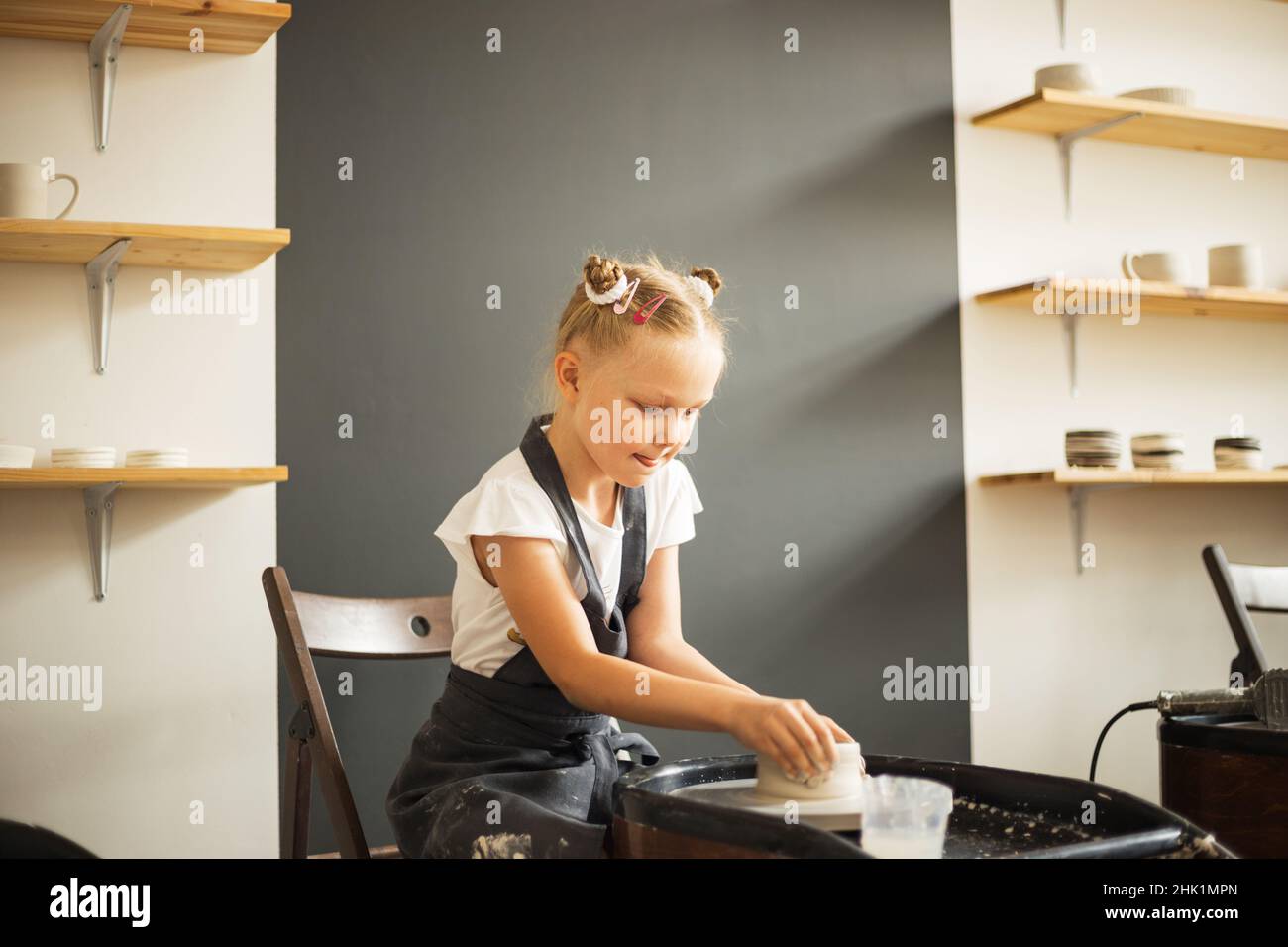 Mädchen, das mit Ton auf einem Töpferrad arbeitet. Traditionelles Handwerk. Stockfoto