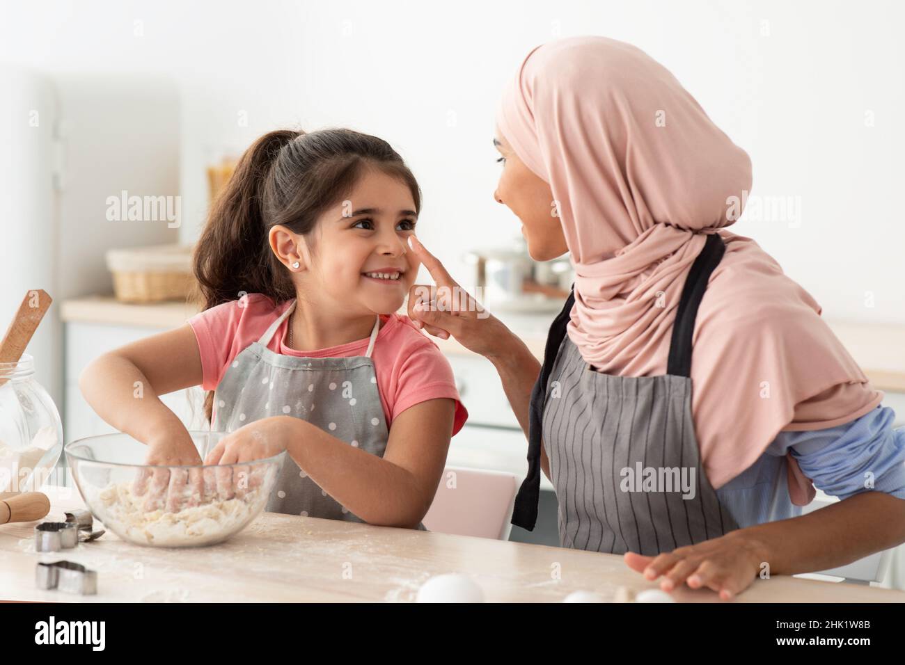 Mutter Tochter Freizeit. Glücklich Islamische Mutter Und Nette Weibliche Kind Backen Zusammen Stockfoto