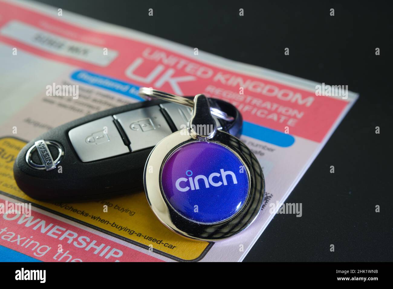 Cinch Cars Logo auf dem Schlüsselring des Autos auf dem drahtlosen Nissan-Schlüssel, der auf dem Registrierungszertifikat V5C platziert ist. Chinch ist Online-Autohändler für Gebrauchtwagen. Staffo Stockfoto