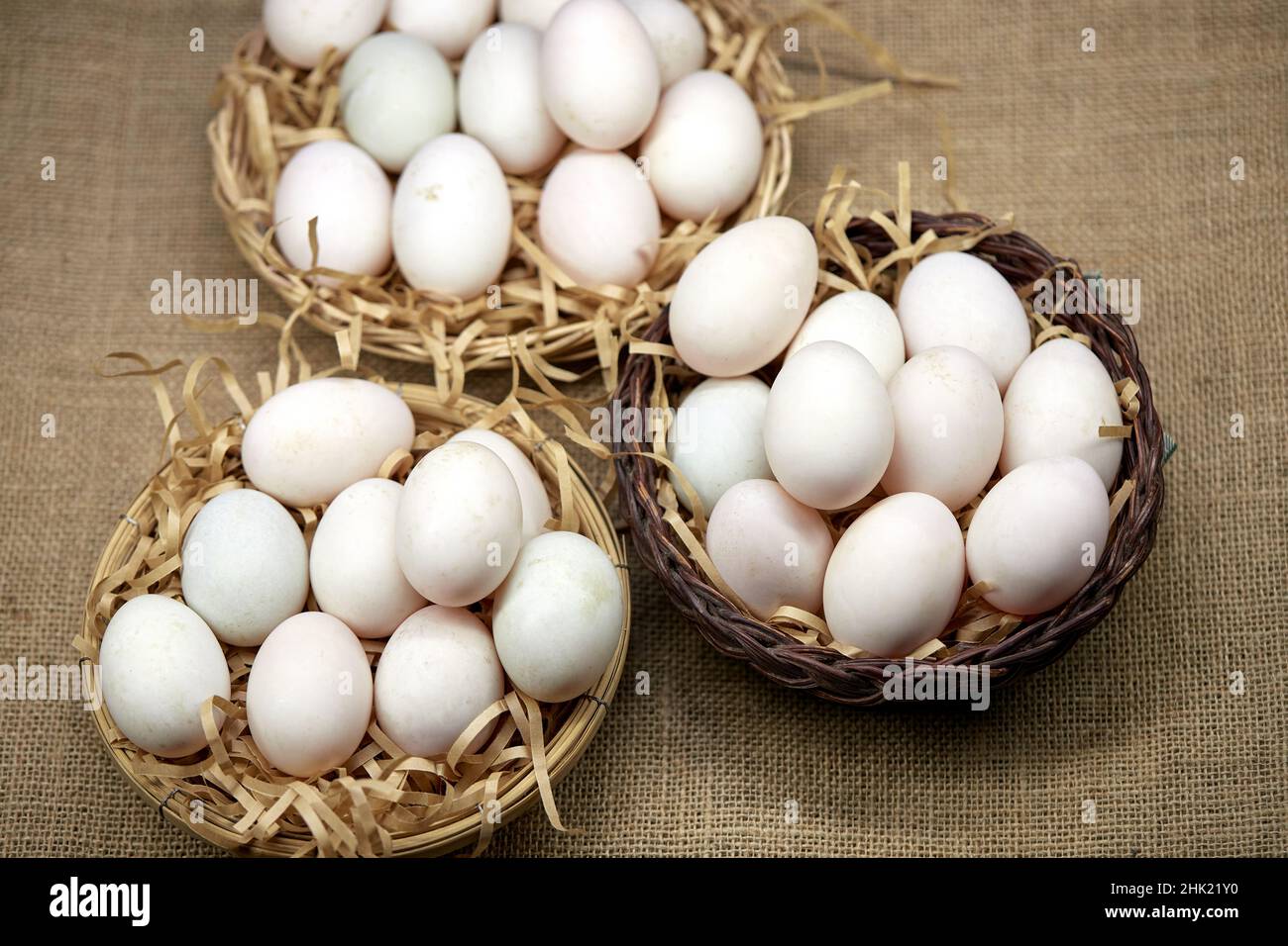 Rohe Bio-Whhite-Eier im Weidenkorb Stockfoto