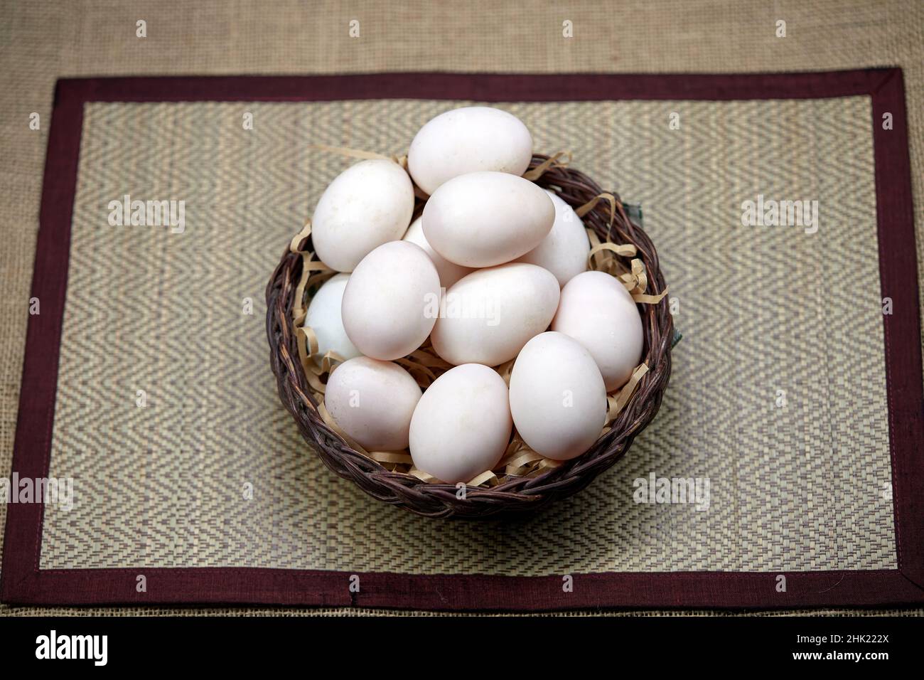 Rohe Bio-Whhite-Eier im Weidenkorb Stockfoto