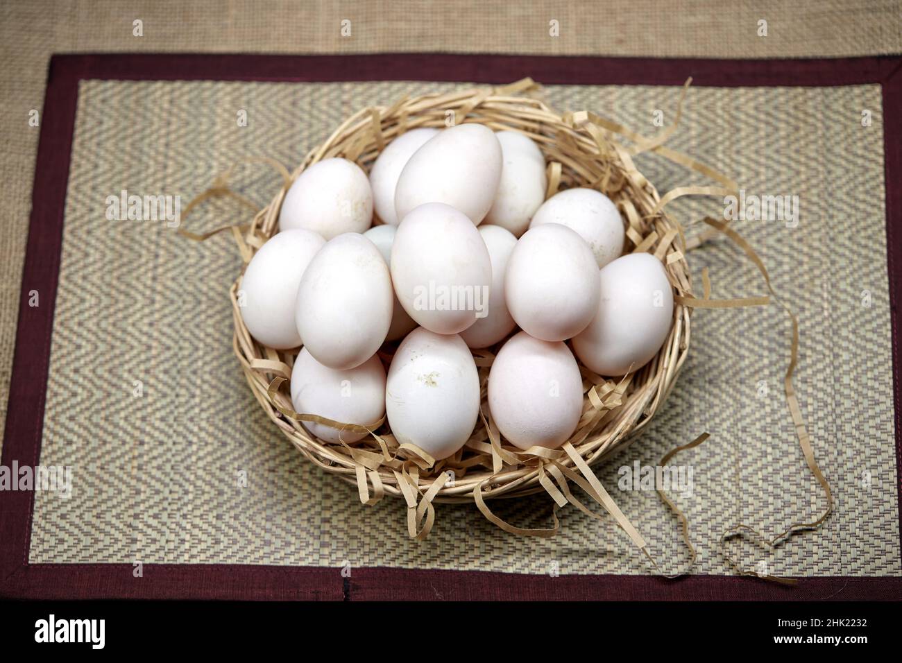 Rohe Bio-Whhite-Eier im Weidenkorb Stockfoto