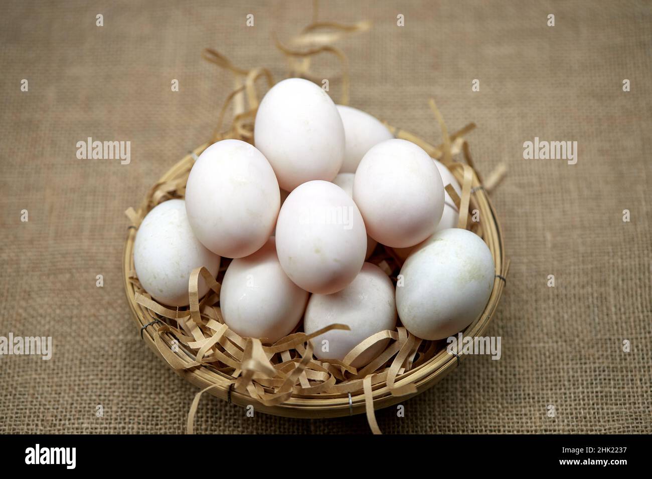 Rohe Bio-Whhite-Eier im Weidenkorb Stockfoto