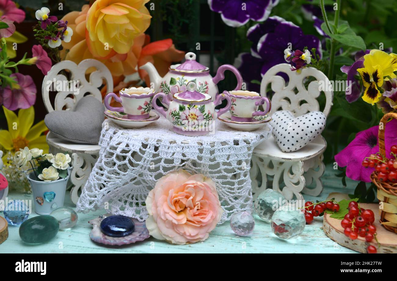 Winzig entzückender Tisch und Stühle für eine Teeparty mit Blumen und Beeren. Feen im Garten. Schöne Fabel Stillleben für Grußkarten, Hochzeit oder Stockfoto