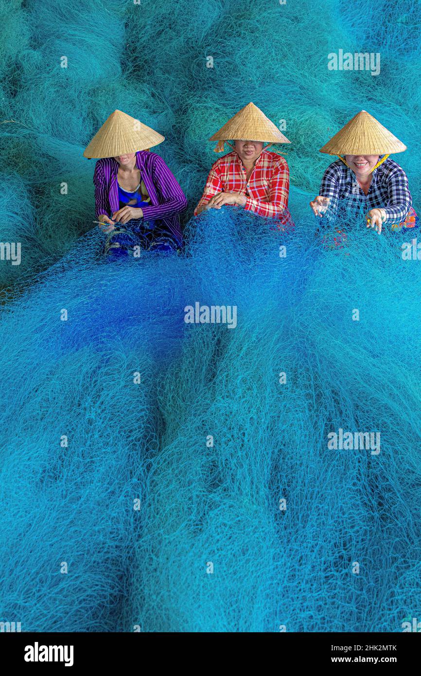Vietnam. Frauen reparieren Fischernetze. Stockfoto