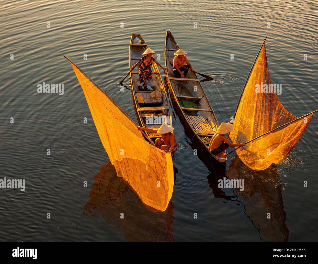 Vietnam. Koordinierte Lagunenfischerei mit Netzen bei Sonnenuntergang. Stockfoto