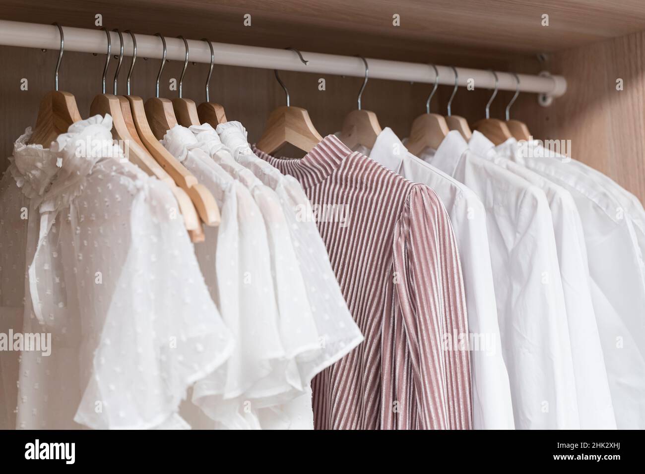 Kleidung im Schrank. Leichte Vintage-Damenbekleidung auf Kleiderbügeln im Schrank der Ankleidekabine. Modetrends, Textilien, Recycling, aus zweiter Hand. Hochwertige Fotos Stockfoto