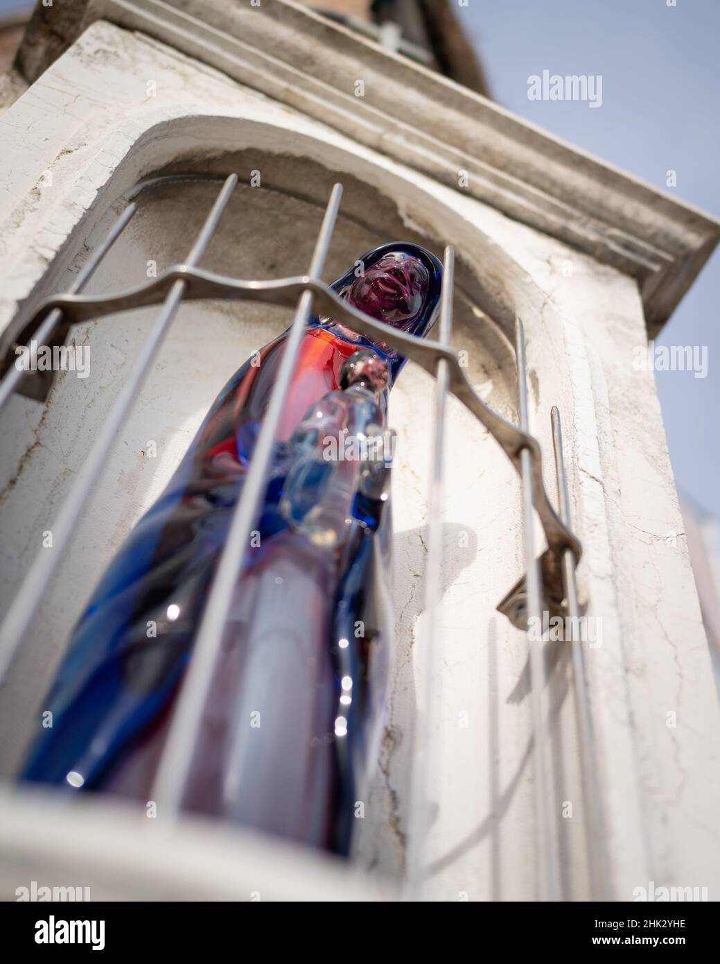 Murano, Italien - 25. Oktober 2021: Statue der heiligen Maria aus buntem Glas, Hausecke, wolkiger Herbsttag Stockfoto