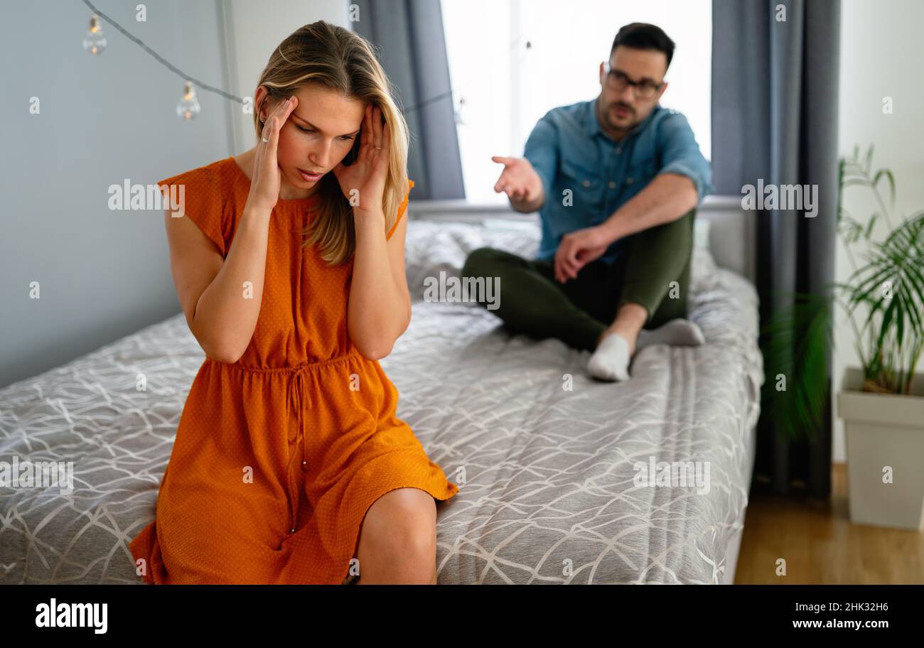 Traurige, nachdenkliche Paare, die an Beziehungsprobleme denken, die auf dem Sofa sitzen, Konflikte in der Ehe. Stockfoto