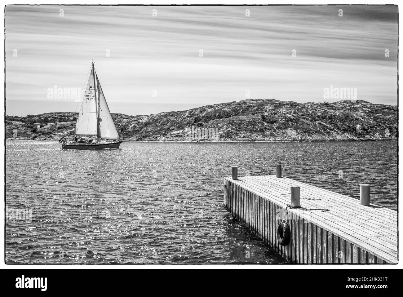 Schweden, Bohuslan, Orust Island, Mollosund, Pier und Segelboot Stockfoto