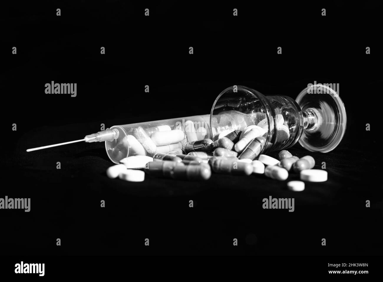 Gelatinekapsuless und Tabletten Pharmazeutika aus gefallener Glas dunklen Hintergrund, Pillen Stockfoto