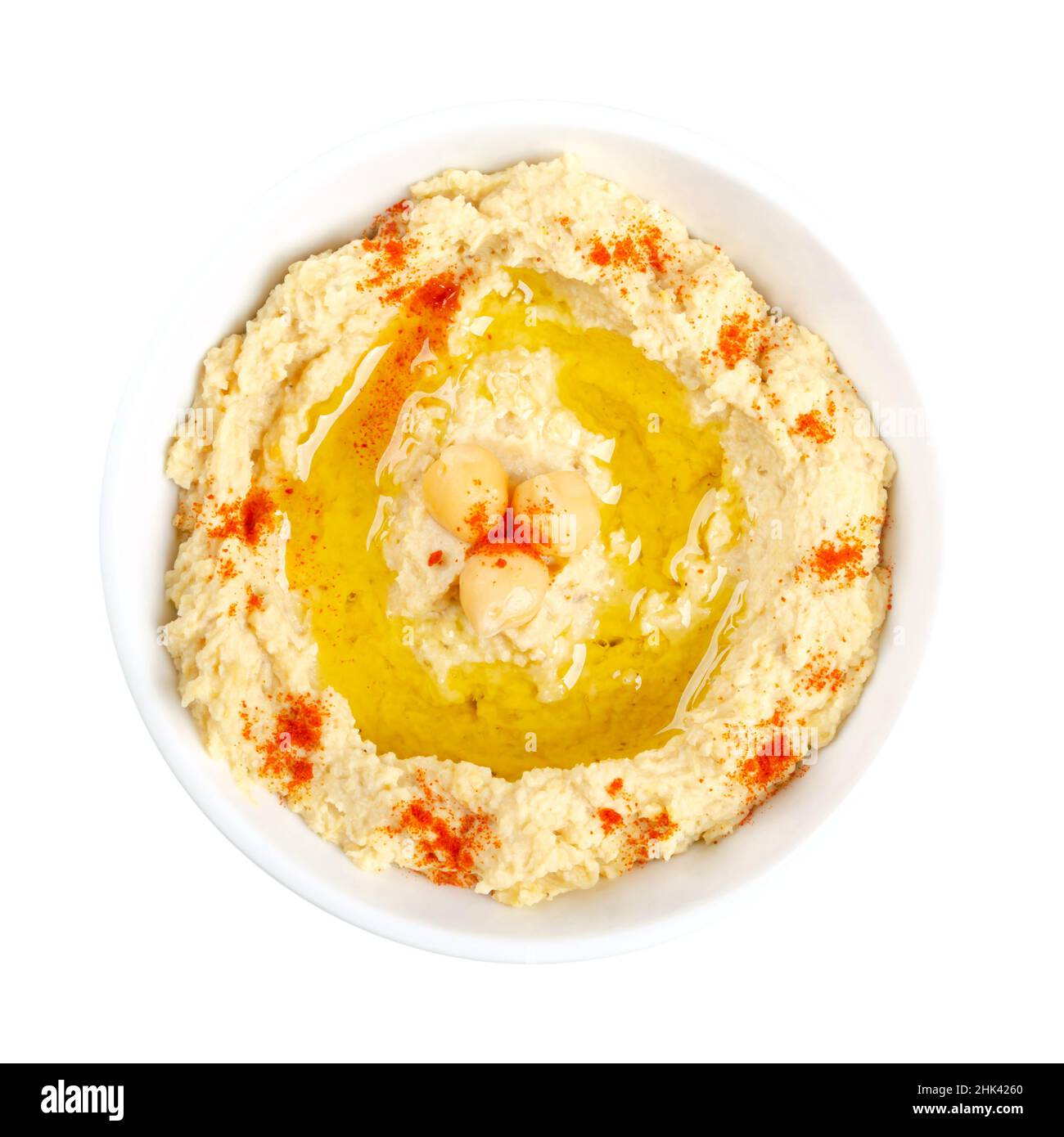 Hummus Dip mit Paprikapulver und Olivenöl, in einer weißen Schüssel. Nahost-Dip, Aufstrich oder herzhaftes Gericht aus gekochten, pürierten Kichererbsen. Stockfoto