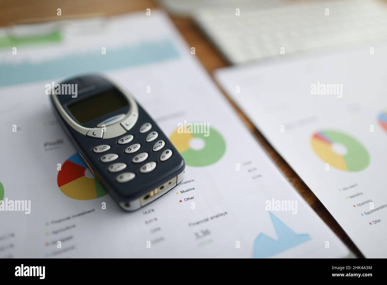 Nokia 3310 Mobiltelefon liegt auf Dokumenten mit Grafiken in Nahaufnahme Stockfoto