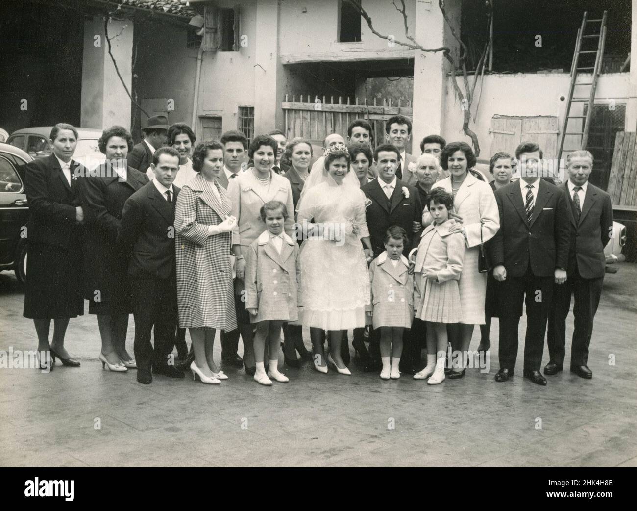 Hochzeit in Italien während des 1950s: Die Braut und der Bräutigam machen das Foto mit allen Gästen Stockfoto