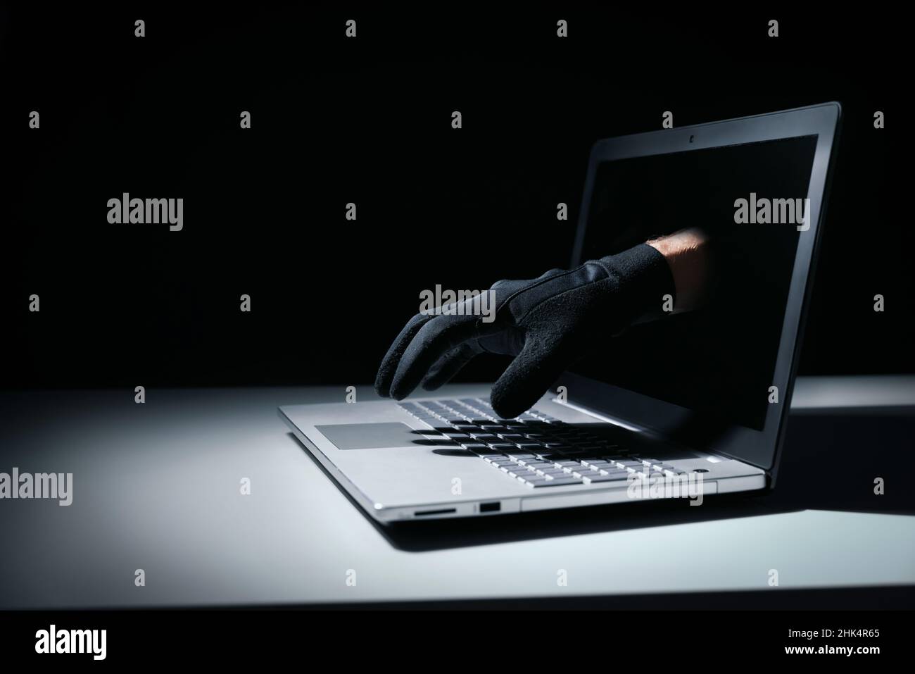 internet-Betrug und Cyber-Angriff Konzept. Dieb Hand aus Laptop-Bildschirm Stockfoto