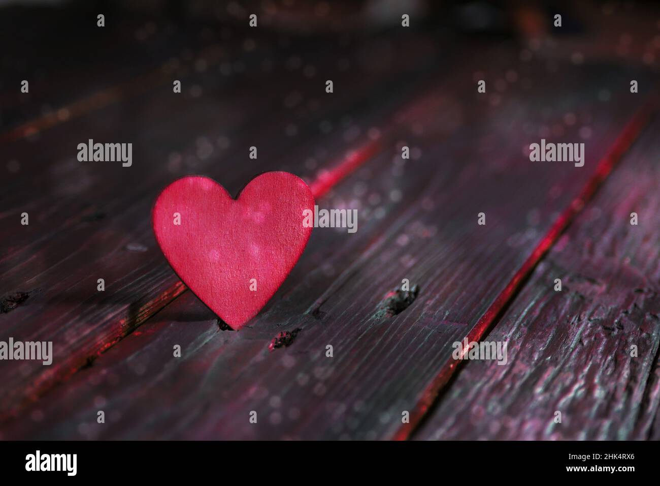 Rosafarbenes Herz auf dunklen rustikalen Holzplanken, auffälliges Liebeskonzept für Valentinstag, Muttertag, Vatertag oder Geburtstag, Kopierraum, ausgewählter Fokus, Narro Stockfoto