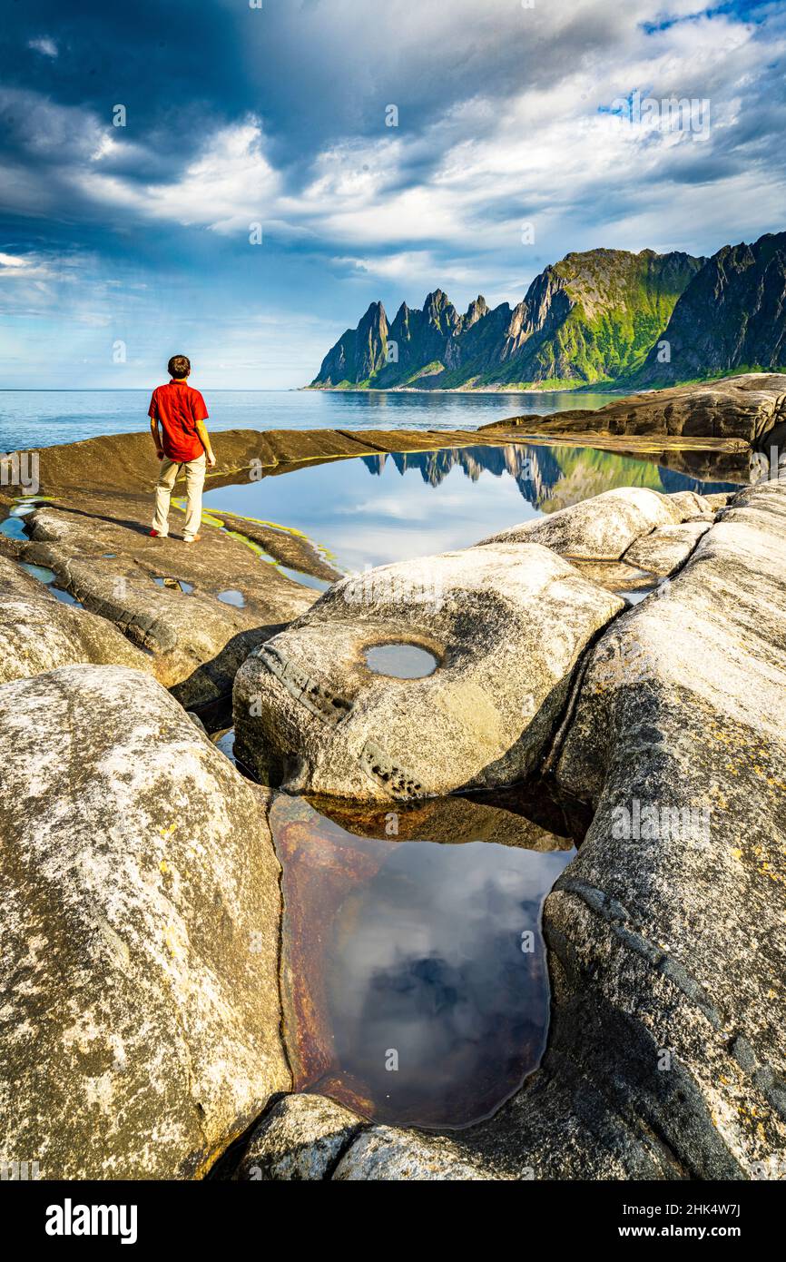 Wanderer, der die scharfen Felsen der Berggipfel neben den Felsenbecken betrachtet, Tungeneset, Senja, Troms County, Norwegen, Skandinavien, Europa Stockfoto