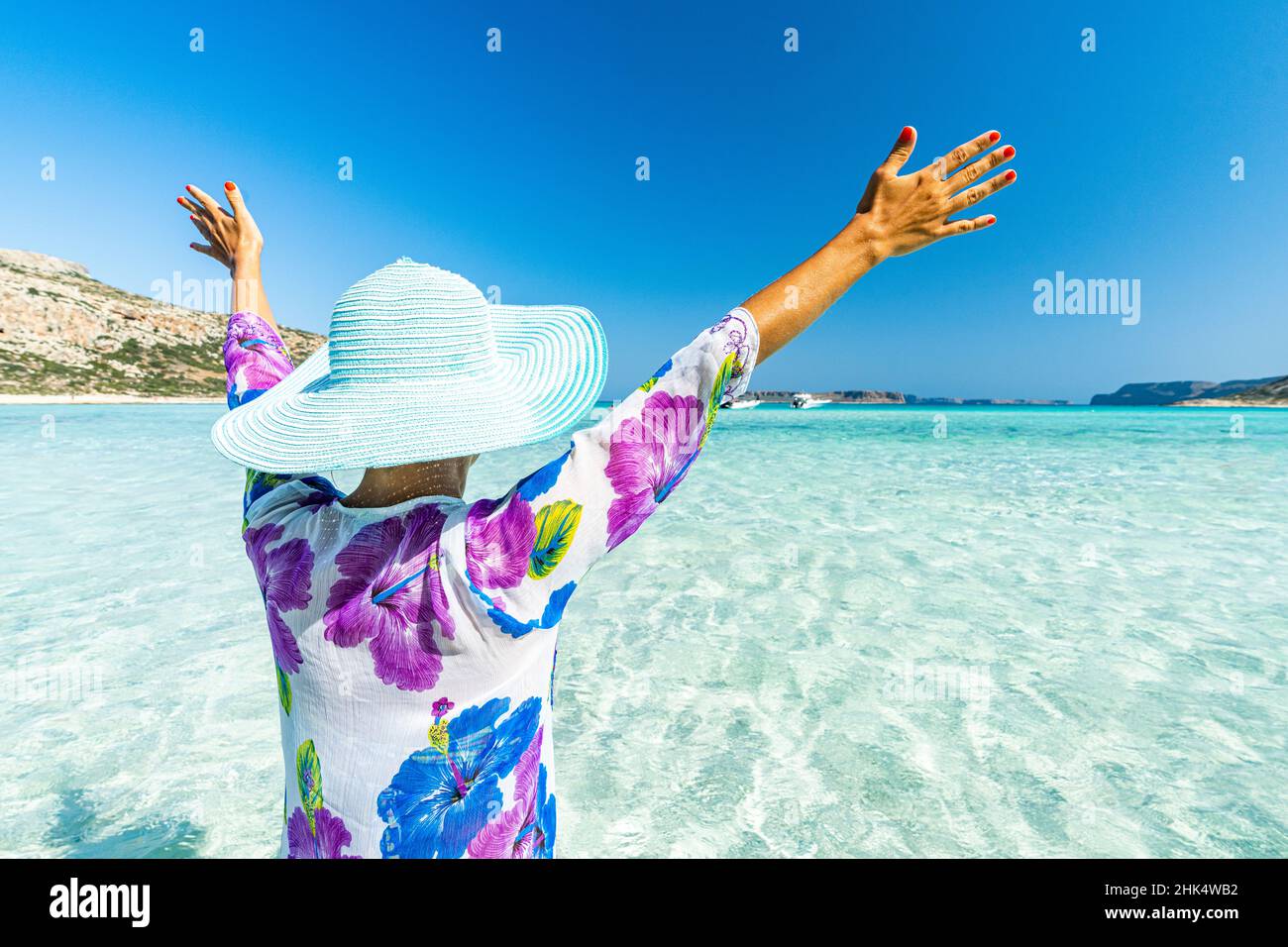 Fröhliche Frau mit Armen angehoben Sonnenbaden im klaren Meer, Kreta, griechische Inseln, Griechenland, Europa Stockfoto