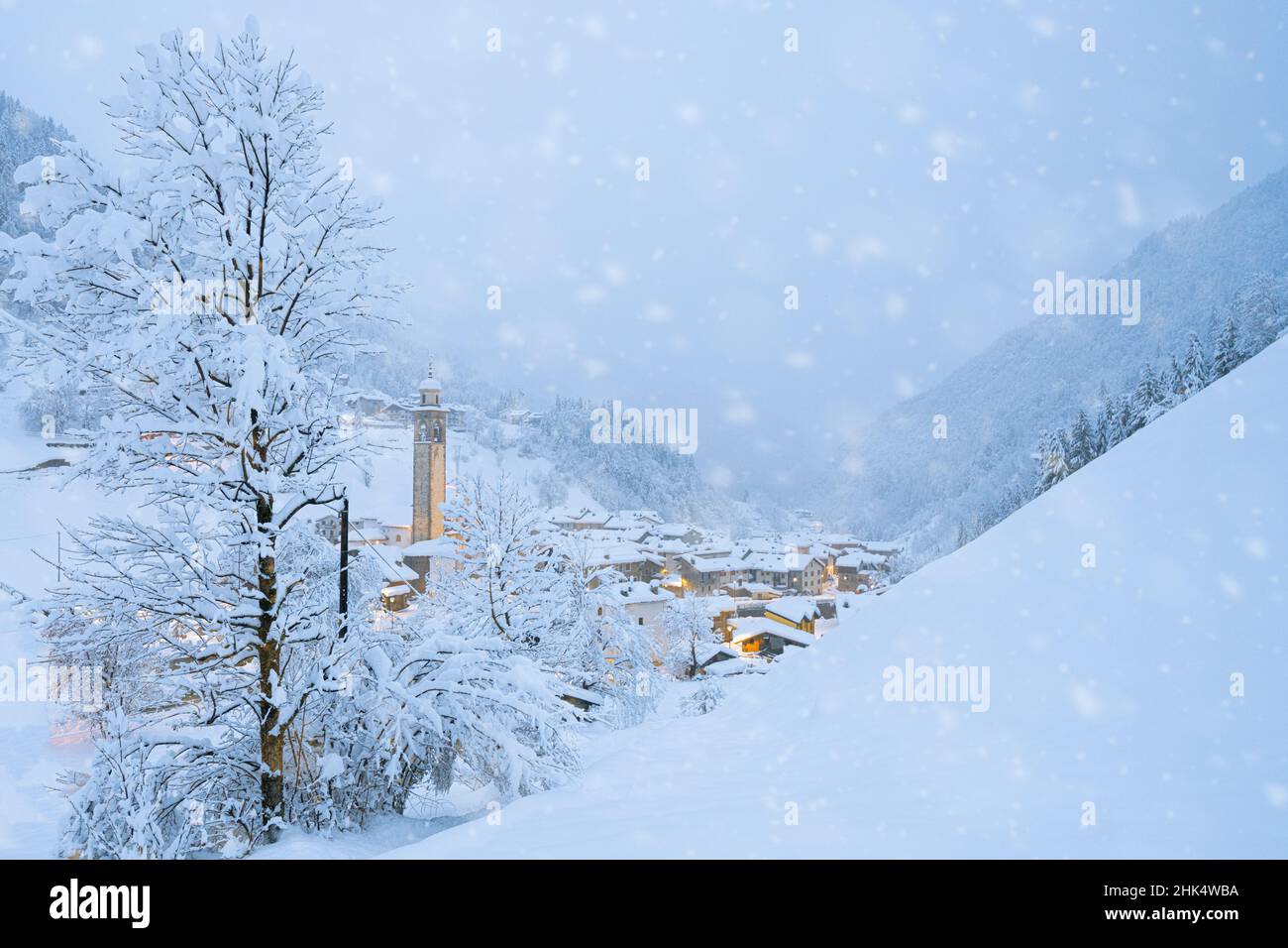 Schneeflocken fallen auf Berghütten im märchenhaften Alpendorf zur Weihnachtszeit, Valgerola, Valtellina, Lombardei, Italien, Europa Stockfoto