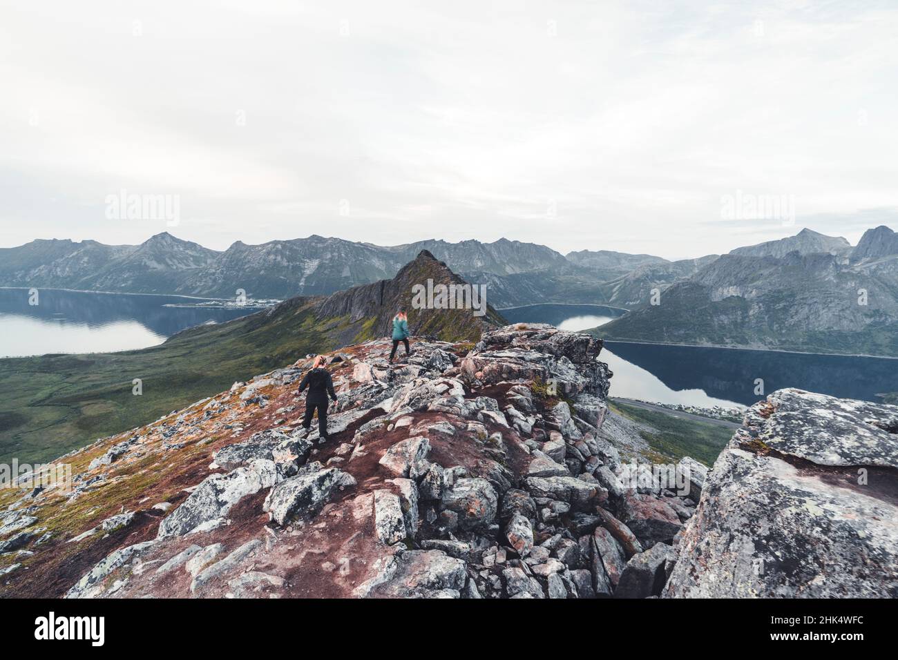 Zwei junge Wandererinnen, die die Felsen auf dem Hesten-Gipfel, Senja, Troms County, Norwegen, Skandinavien, Europa Stockfoto