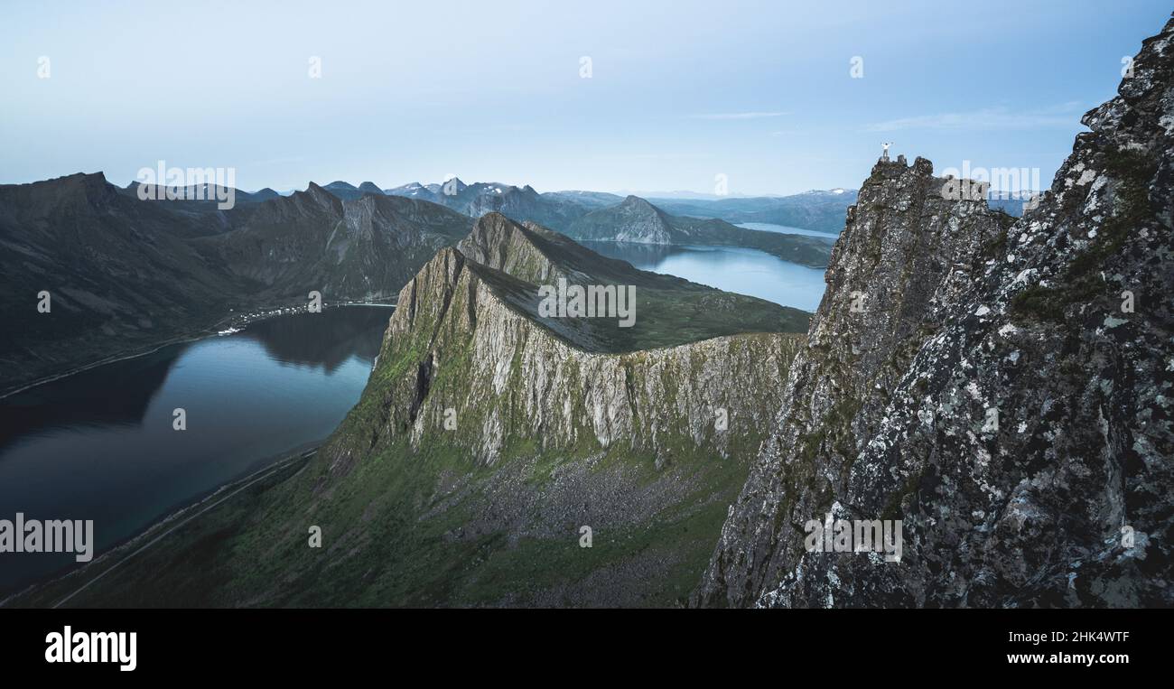 Wanderer, die den Fjord in der Abenddämmerung vom Gipfel des Husfjellet, der Insel Senja, der Grafschaft Troms, Norwegen, Skandinavien, Europa Stockfoto