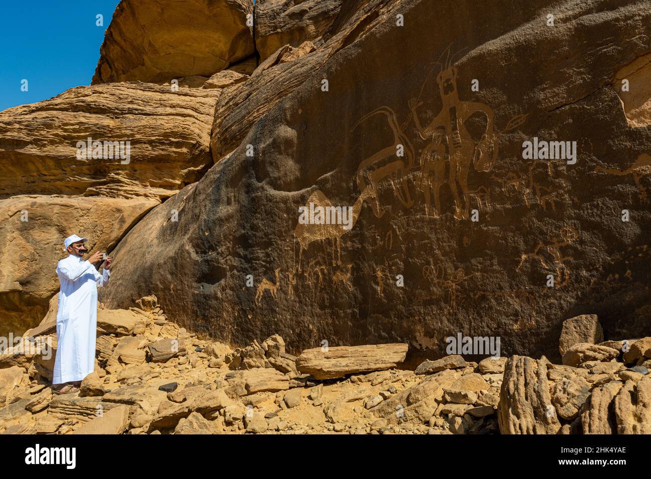 Mann zeigt auf Felszeichnungen, Felszeichnungen und Inschriften von Bir Hima, UNESCO-Weltkulturerbe, Najran, Königreich Saudi-Arabien, Naher Osten Stockfoto