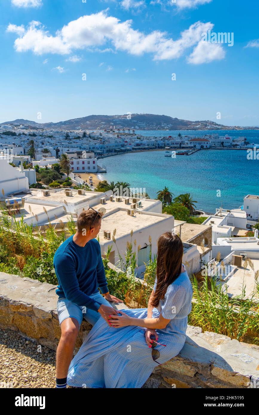 Junges Paar mit erhöhter Sicht auf die Mühlen und die Stadt, Mykonos-Stadt, Mykonos, Kykladen-Inseln, griechische Inseln, Ägäis, Griechenland, Europa Stockfoto