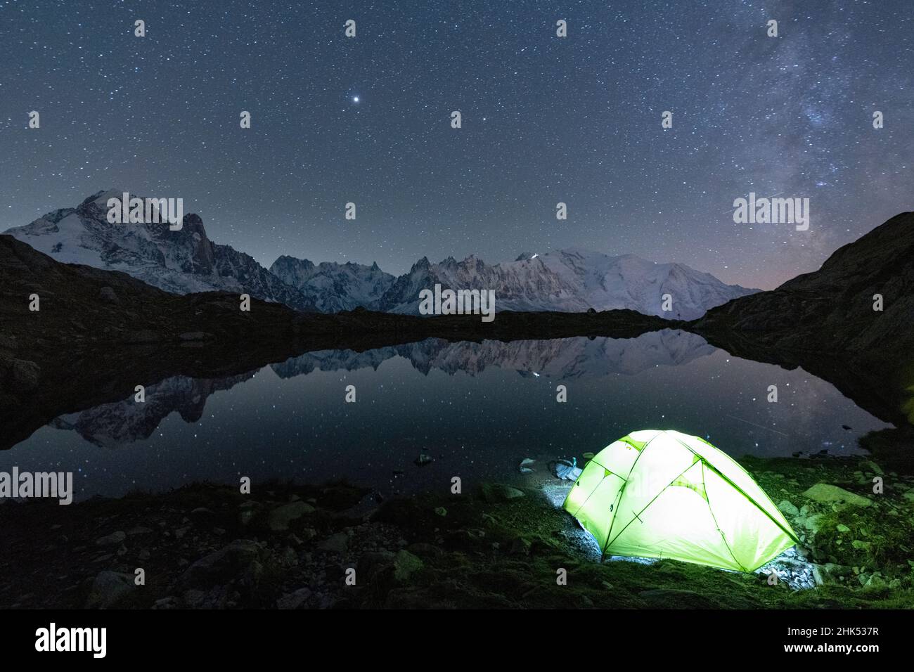 Leuchtendes Zelt unter den Sternen bei Lacs des Cheserys mit Mont Blanc-Massiv im Wasser, Chamonix, Haute Savoie, Französische Alpen, Frankreich, Europa Stockfoto