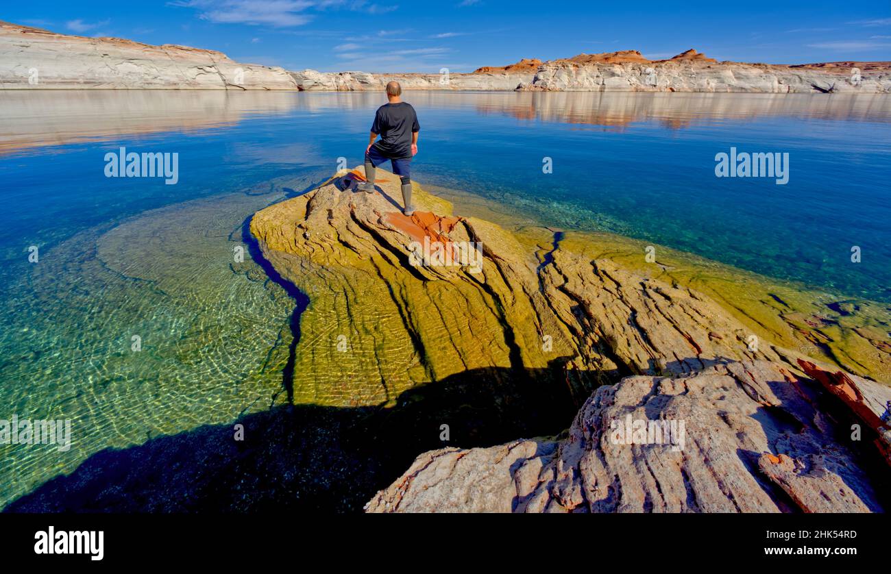 Ein Wanderer, der auf einer Felsenhalbinsel am Lake Powell, Arizona, USA, Nordamerika, steht Stockfoto