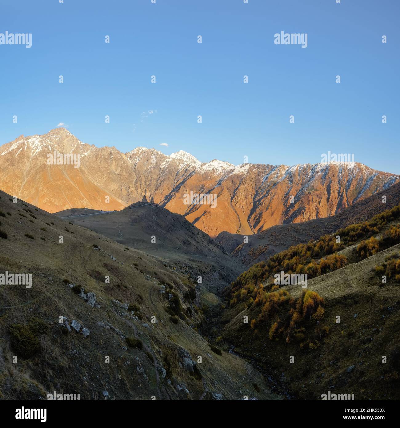 Herbstansicht der Gergeti Trinity Church bei Sonnenuntergang, Kazbegi, Georgien (Sakartvelo), Zentralasien, Asien Stockfoto