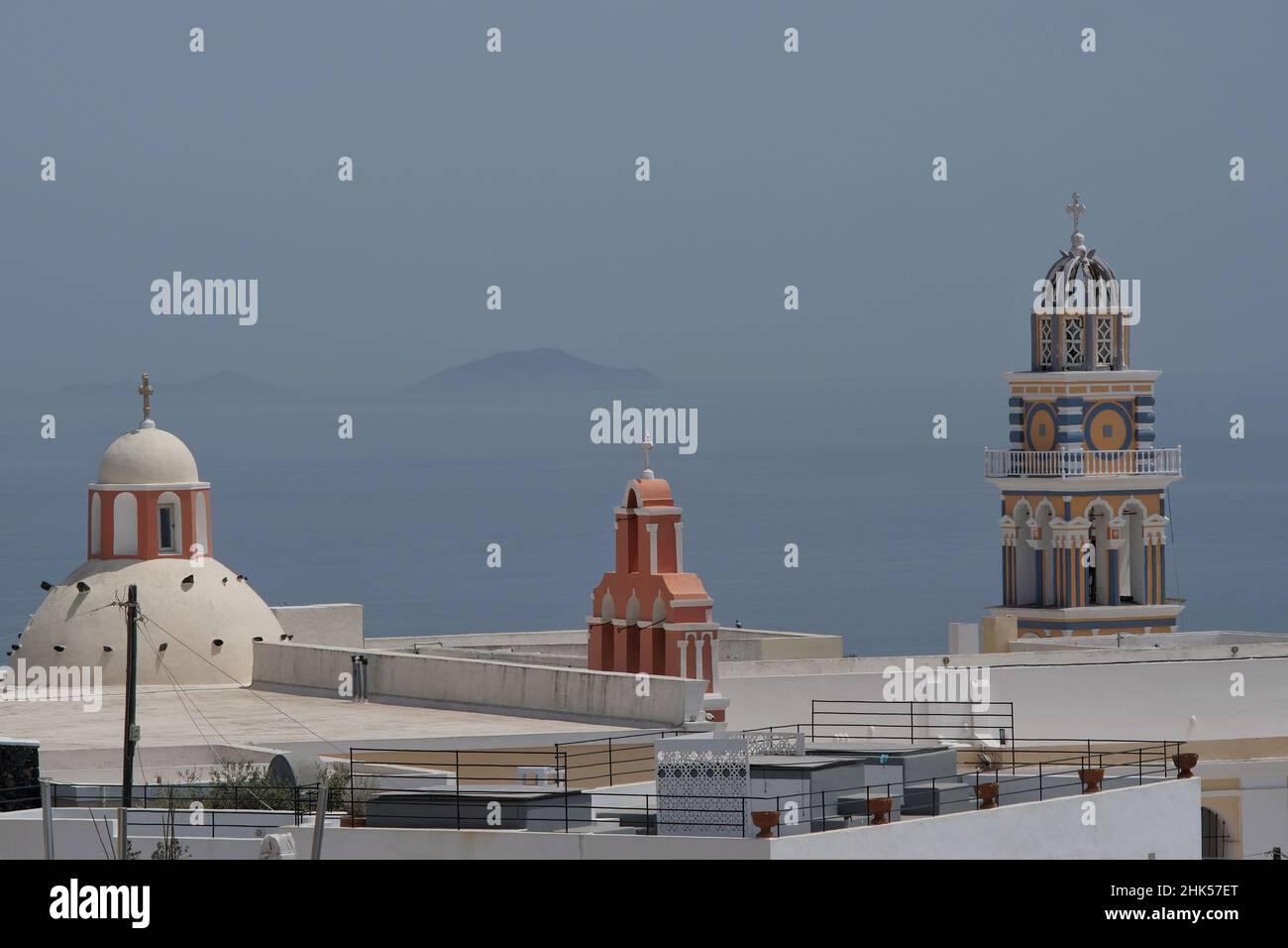 Blick auf drei orthodoxe Kirchen in Santorini und die Insel Anafi im Hintergrund Stockfoto