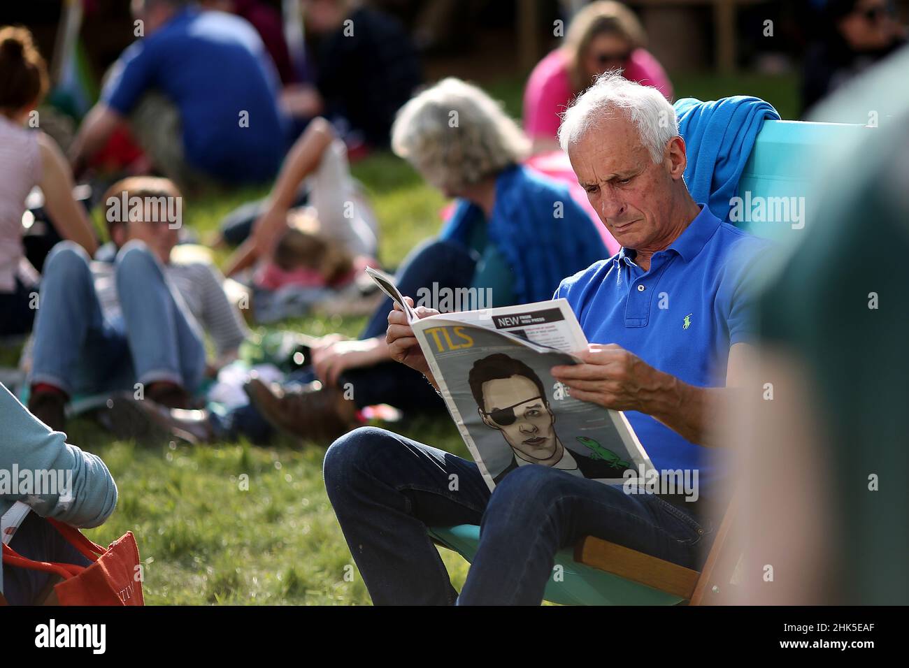 Hay Festival, ein Mann liest eine Zeitungsbeilage in der Sonne auf dem Grün in Hay-on-Wye, Powys, Wales am 27th. Mai 2018. Stockfoto Hay Festival, ein Mann liest eine Zeitungsbeilage in der Sonne auf dem Grün in Hay-on-Wye, Powys, Wales am 27th. Mai 2018. Stockfoto