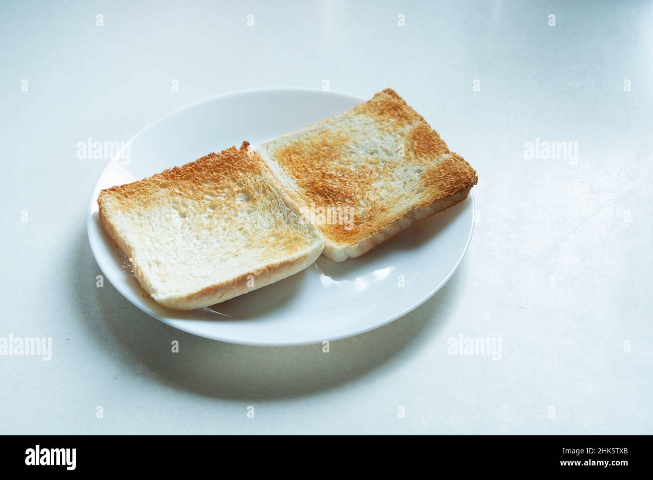 Zwei gebackene Toasts liegen auf einem weißen Teller Stockfoto