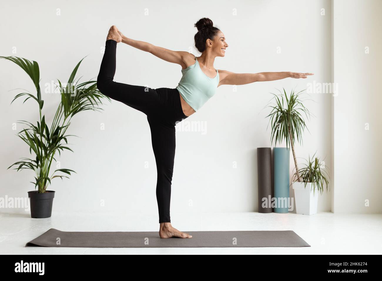 Junge Brünette Frau Praktiziert Yoga In Lord Of The Dance Pose, Stockfoto