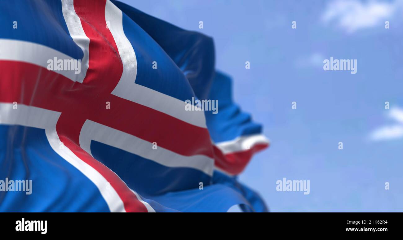 Detail der Nationalflagge Islands, die an einem klaren Tag im Wind winkt. Demokratie und Politik. Patriotismus. Selektiver Fokus. Nahtlose Zeitlupe Stockfoto