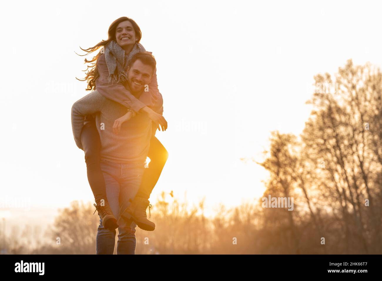 Ein junges heterosexuelles Paar, das am valentinstag in einem Park herumläuft und spielt Stockfoto