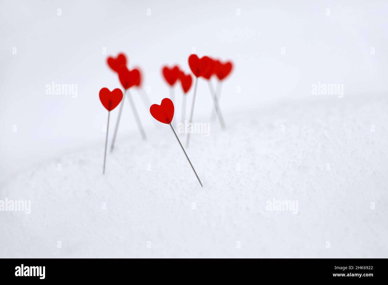 Rote Herzen auf dem Schnee, Symbole der Liebe. Hintergrund für romantische Grußkarte, Valentinstag Stockfoto