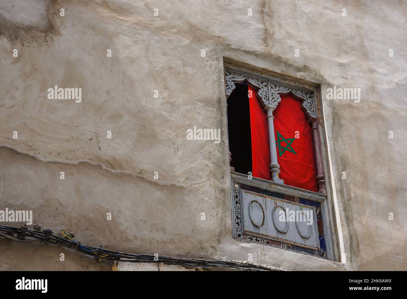 Marokkanische Flagge, die in einem Fenster mit traditionellen Ornamenten hängt Stockfoto