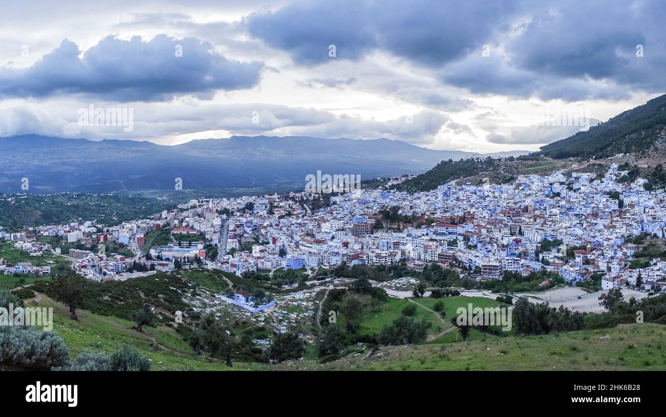 Panoramablick auf die ganze Stadt Chefchaouen mit ihren blau und weiß gestrichenen Gebäuden, umgeben von Hügeln Stockfoto