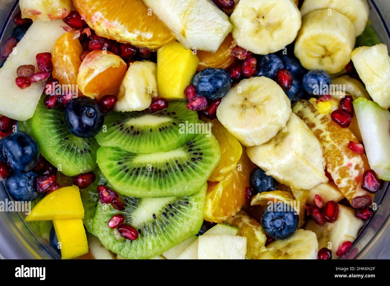 Nahaufnahme farbenfroher Obstsalat in einer Schüssel mit vielen verschiedenen Obstsorten wie Kiwi-Banane und Heidelbeeren Stockfoto