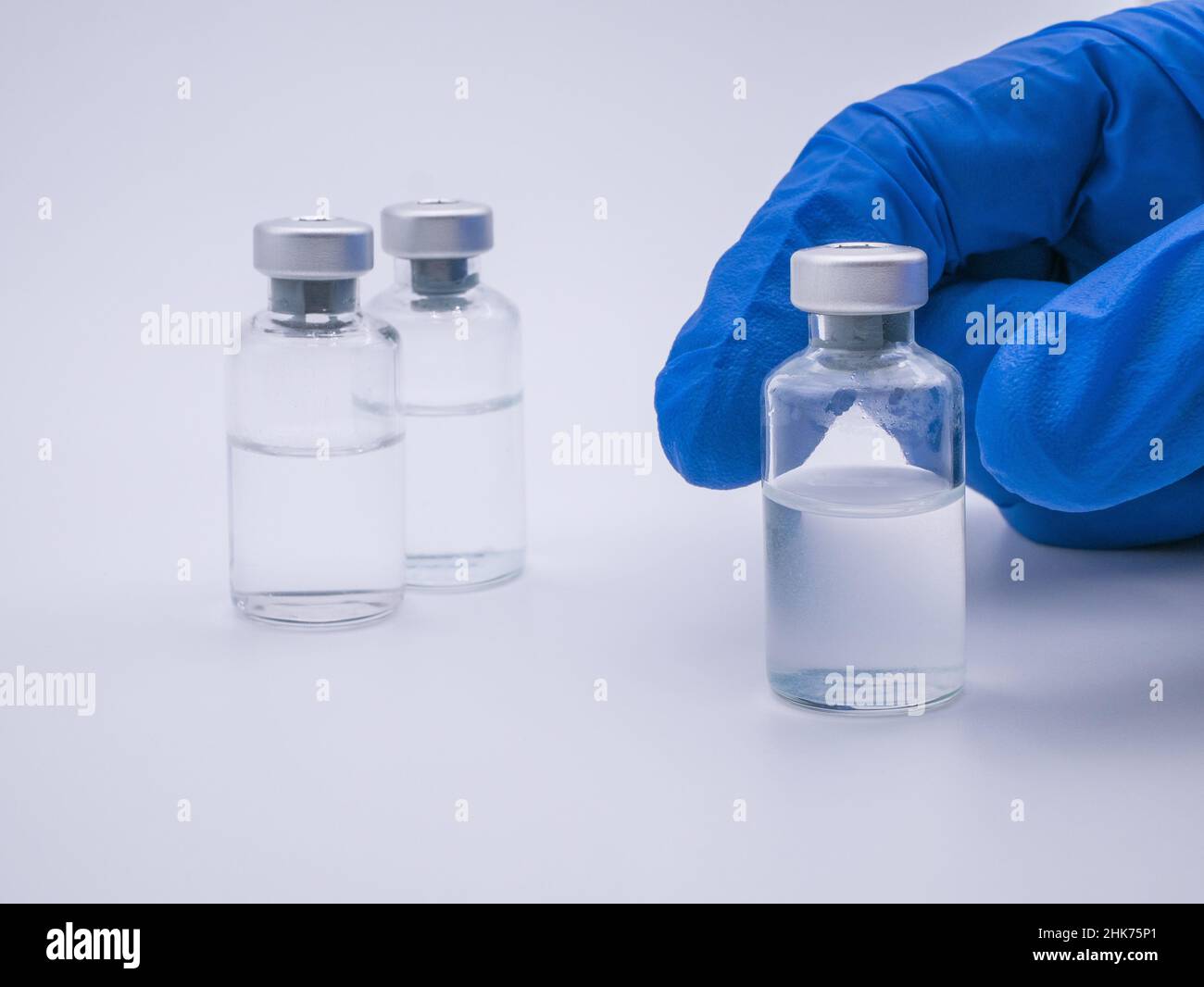 Handhaltenden Impfstoffflasche isoliert auf weißem Hintergrund Stockfoto