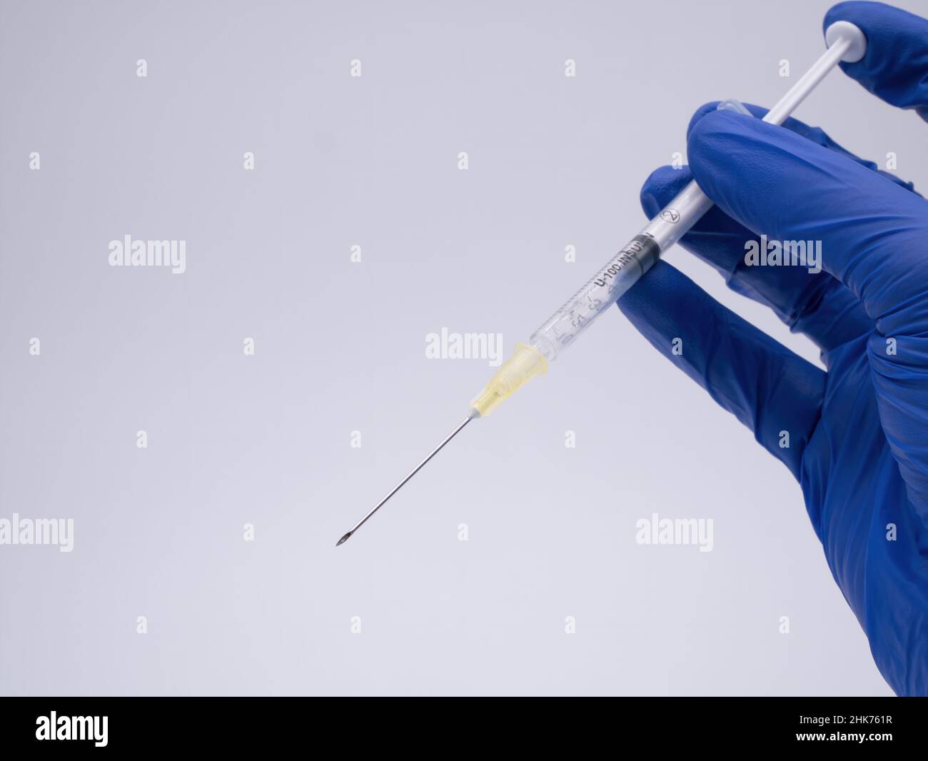 Hand mit Handschuh, der die medizinische Spritze hält Stockfoto