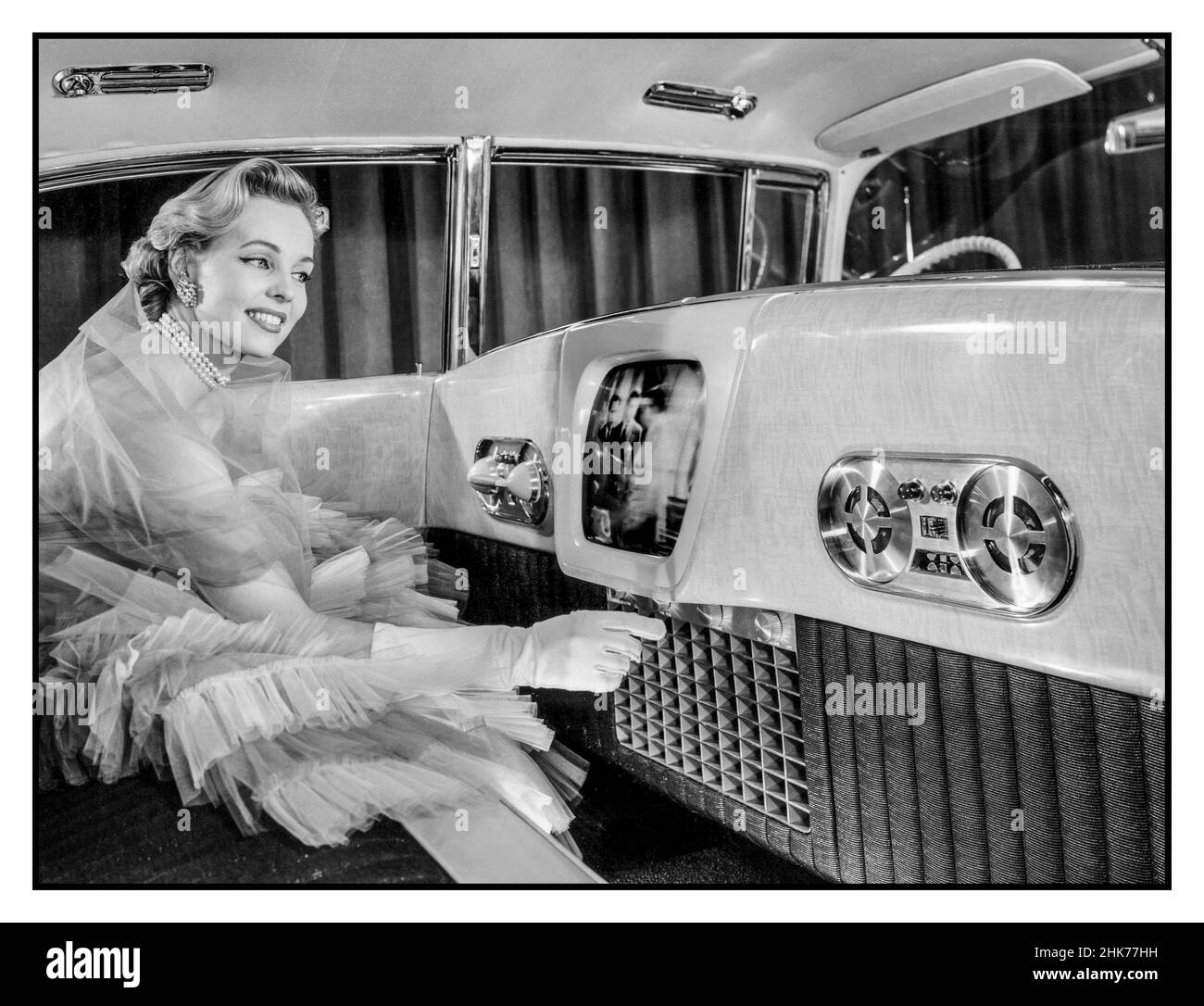Vintage 1955 Cadillac Westchester Luxus-Innenraum-Auto Auto mit Telefon, Tonbandgerät und 14' TV Automobile Car Show, mit weiblichem Modell demonstriert eine Vision der Automobil-Zukunft mit Luxus-Zubehör wie in-Car-TV-Telefon 14-Zoll-Fernseher, ein Telefon, Tonbandgerät, Und Korina-Goldholzvertäfelung unter den ungewöhnlichen Luxusmerkmalen des Cadillac Westchester Showcar aus dem Jahr 1955 Stockfoto